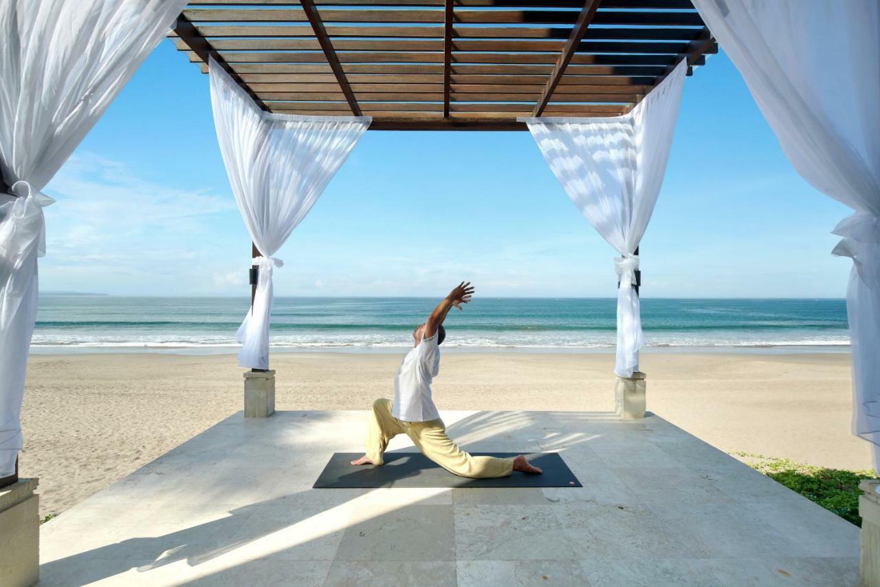 The Seminyak Beach Resort & Spa Екстер'єр фото A man practicing yoga at the beach